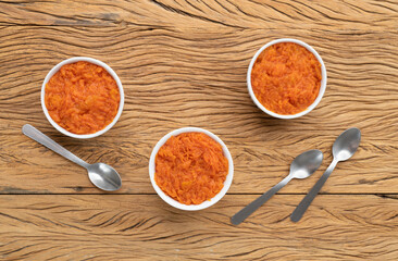 Traditional brazilian pumpkin sweet dessert with spoons over wooden table