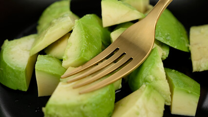 mashing avocado in a bowl with fork. Making guacamole sauce mashing avocado. Cooking healthy vegan food