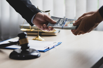 Business people shaking hands and bribe to an attorney to help a lawyer win a court case. The concept of bribing lawyers and paying lawsuits. - obrazy, fototapety, plakaty