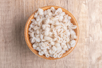 Job's tears boiled in a cup with a wooden spoon. Healthy whole grains.