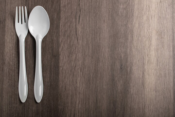 white spoon and fork on gray background