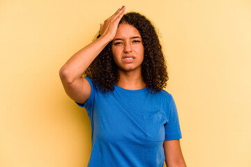 Young Brazilian woman isolated on yellow background forgetting something, slapping forehead with...