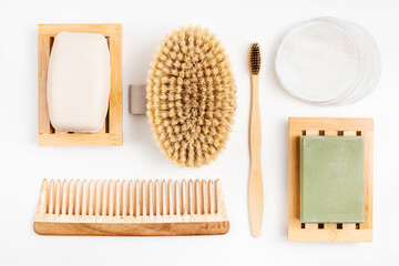 Zero waste beauty products, sustainable bathroom and eco-friendly lifestyle. Bamboo toothbrush, organic soap in wooden dish, cotton make-up pads. wood body brush and hair comb.
