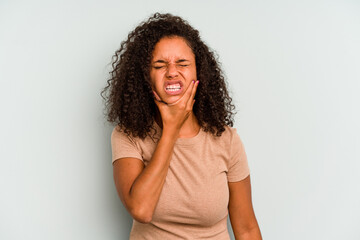 Young Brazilian woman isolated on blue background having a strong teeth pain, molar ache.