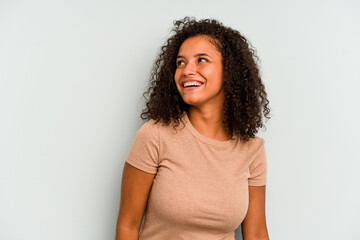 Young Brazilian woman isolated on blue background relaxed and happy laughing, neck stretched showing teeth.