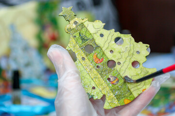Female hand paint wooden New year decoration (Christmas tree). Decoupage process. Creativity, hobby, DIY concept background  