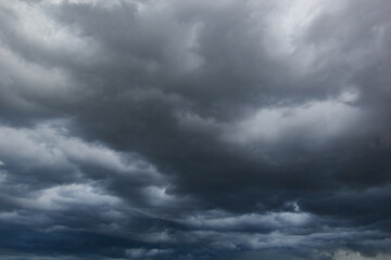 The dark sky with heavy clouds converging and a violent storm before the rain.Bad or moody weather sky and environment. carbon dioxide emissions, greenhouse effect, global warming, climate change.