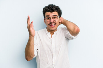 Naklejka premium Young caucasian man isolated on blue background screaming with rage.