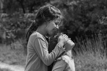 Little friends play together, close their eyes, have fun outdoors in the village