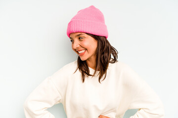 Young hispanic woman isolated on blue background looking sideways with doubtful and skeptical expression.