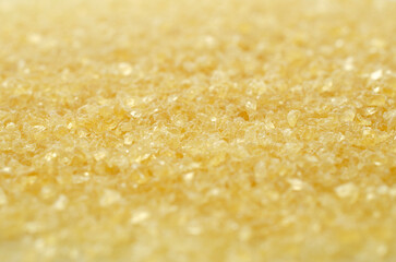 Gelatin, yellow powder top view. Background, texture of crystals of gelatin, close-up. Dry gelatin texture, top view. Dry yellow gelatin powder, top view. Pile of isinglass, top view.
