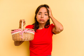 Young hispanic woman going to do it picnic isolated on yellow background being shocked, she has remembered important meeting.