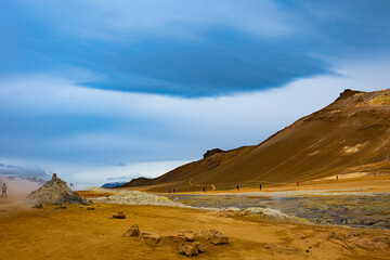 Small human figures as a measure of scale in out of this world landscape in active geothermal area in Iceland