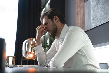 Frustrated stressed businessman feel tired having migraine during working. Exhausted man having headache and problem