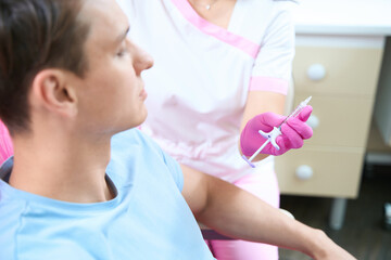 Fototapeta premium Young man preparing for beauty injections in clinic