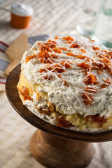Tasty pumpkin and coconut sweet cake, on a wooden cake stand