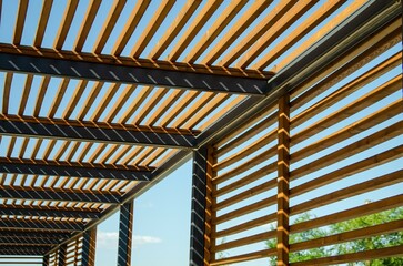 Texture of wooden lattice wall and roof made of parallel boards against blue sky. Abstract urban modern background, geometric perspective