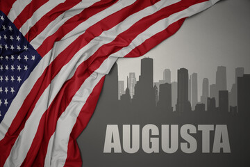 abstract silhouette of the city with text Augusta near waving national flag of united states of america on a gray background. 3D illustration