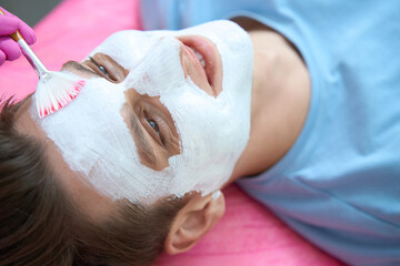 Smiling man enjoying procedures in cosmetologist office
