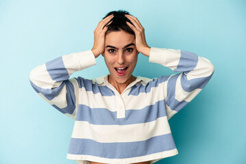 Young caucasian woman isolated on blue background screaming, very excited, passionate, satisfied with something.