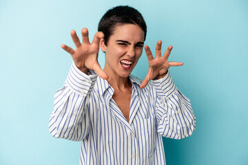Young caucasian woman isolated on blue background upset screaming with tense hands.