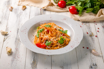 Pasta spaghetti with shrimps and tomato sauce on bowl on grey table