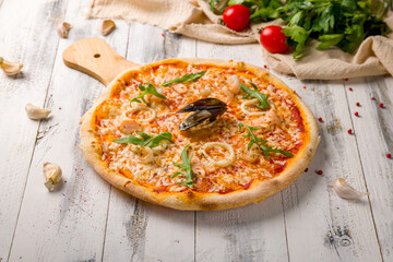 Pizza with seafood on a white wooden table