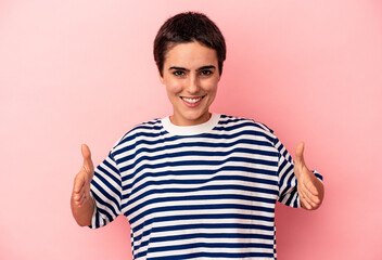 Fototapeta premium Young caucasian woman isolated on blue background holding something with both hands, product presentation.