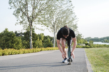 Sport man with physical disability getting ready for training routine outdoor - Focus on prosthetic leg