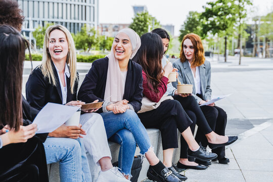 Multiethnic business women eating takeaway lunch break outdoor outside the office - Focus on arab woman face
