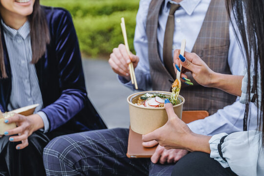 Business People Eating Takeaway Food During Lunch Break Outdoor Outside The Office - Focus On Hand Holding Box