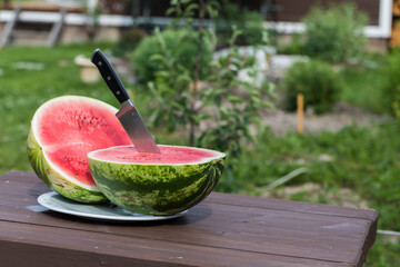 The watermelon was cut into two parts and a knife was inserted. - 515006804