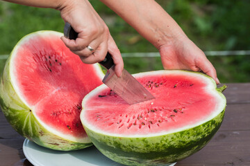 Juicy red watermelon is cut into slices on a wooden table. - 515006837
