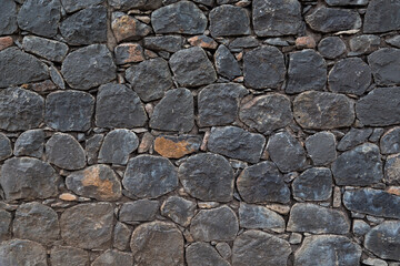 Black Rock stone wall for background, pattern and texture