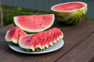 Juicy red watermelon was cut into slices on a wooden table. - 515006882