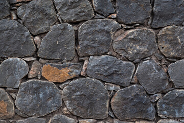 Close up of black rock stone wall for background, pattern and texture