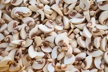 Young champignon mushrooms, sliced into plates. Food background.