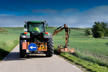 Machine removing weeds on a secondary road in central Spain in springtime