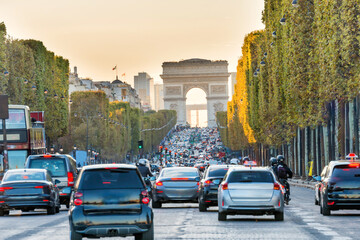Sunset at Avenue des Champs-Elysees with car traffic and view to Arc de Triomphe. Paris, France