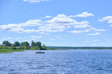 Fototapeta na wymiar Fishermen in a boat on the lake, sunny day