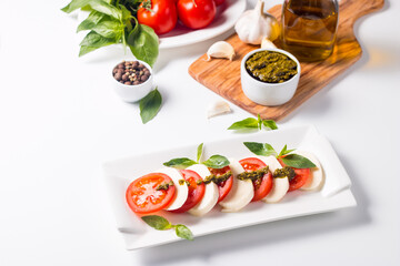 Close-up photo of caprese salad with ripe tomatoes, basil, buffalo mozzarella cheese. Italian and Mediterranean food concept. Fresh and healthy organic meal. Starter and antipasti. 