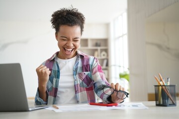 Excited biracial girl student celebrates victory, got email with good scores. Personal achievement - obrazy, fototapety, plakaty