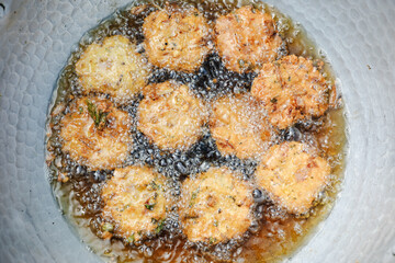 Deep frying masala vada in the pan. very common street food in the India.