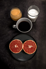 Obraz na płótnie Canvas breakfast with coffee, orange juice, milk and a grapefruit cut in half on a white background with blue plates and a white cup