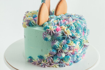 gingerbread cookies on the top of pink birthday cake decorated with cream cheese flowers. Colorful cake for a little girl on the white background