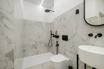 white toilet and black details of corner shower cabin with wall mount shower attachment in elite...