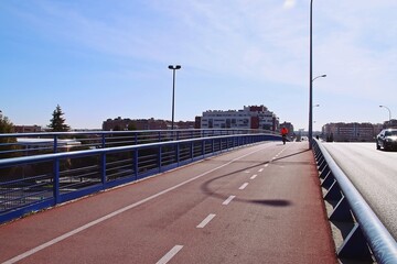 Ciclista practicando deporte en una soleada mañana de invierno. Carril bici en el puente de la...