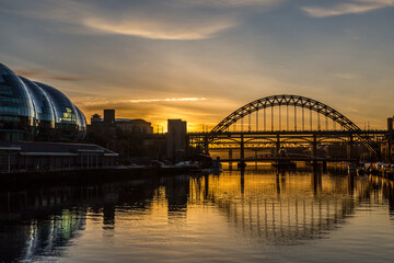 Naklejka premium The Tyne Bridge in Newcastle at sunset, reflecting in the almost still River Tyne beneath