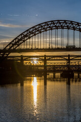 Naklejka premium The Tyne Bridge in Newcastle at sunset, reflecting in the almost still River Tyne beneath
