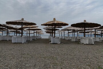 chairs and beach umbrellas at an empty sand beach at Lake Ohrid